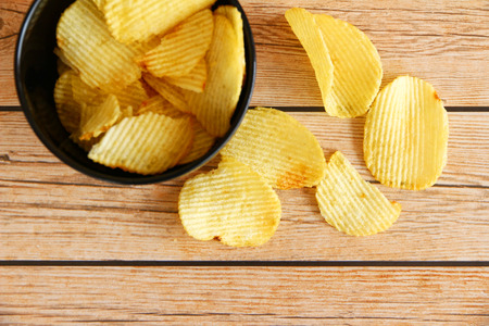 bowl of potato chips on wooden background