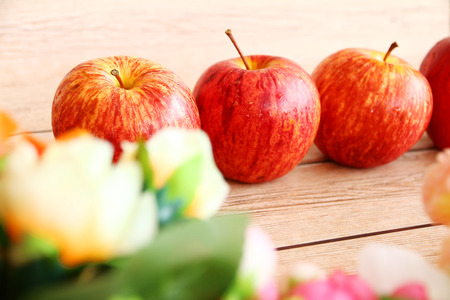 red gala apples with spring fruit tree blossoms on rustic wooden background.