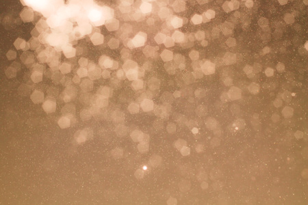 Warm tone background of defocused glittering lights and sparks