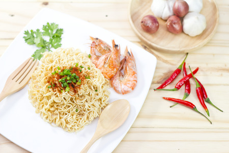 Instant noodles food in white on wooden background.