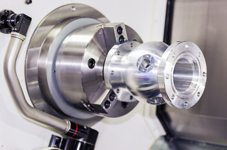 operator turning aluminium autopart by cnc lathe in industrial factoryの写真素材