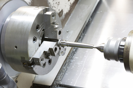 operator machining mold and die part by CNC turning machine in factoryの写真素材