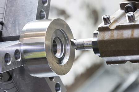 operator machining mold and die part by CNC turning machine in factoryの写真素材