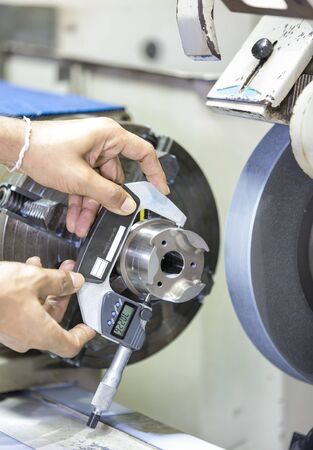 operator grinding forging die parts and inspection dimension after finishing by micrometerの写真素材