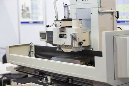 operator grinding surface of mold and die parts by surface grinding machineの写真素材