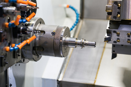 Operator machining automotive part by cnc turning machine