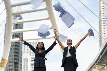 Two business woman happy with their job, funny job, document work of business womanの写真素材