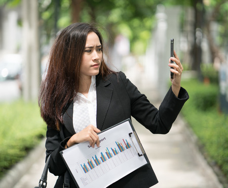 Young businesswoman feeling tired of being pursued by the chief. Business communication Reporting and presentations via mobileの写真素材