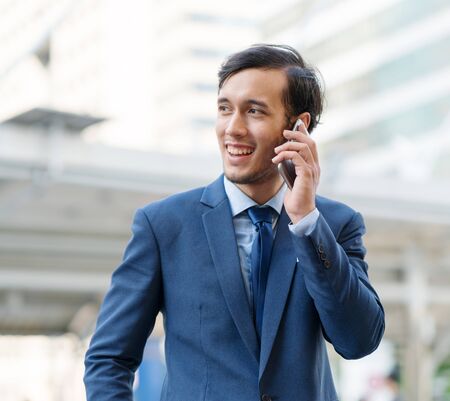 Young businessman talking to a partner. Business communication by device Finding information and communicating with your phone Talk happy phoneの写真素材