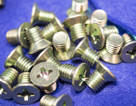 screw on blue background. Industirial screw and bolt manyfacturing. screw coating with chromium zinc plating anodizing.の写真素材
