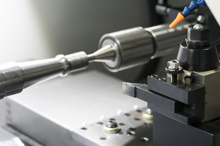 Operator machining automotive part by cnc turning machine, Multi axis CNC turning and milling...