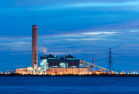 Power stations edge the sea at Rayong, Thailand.の写真素材