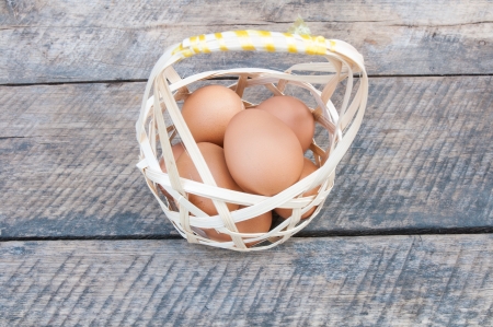 Eggs in basket  and wood on backgroundの写真素材