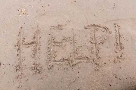 Help! stranded on the beach write sandの写真素材