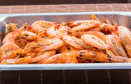 baked orange shrimps in the aluminum trayの写真素材