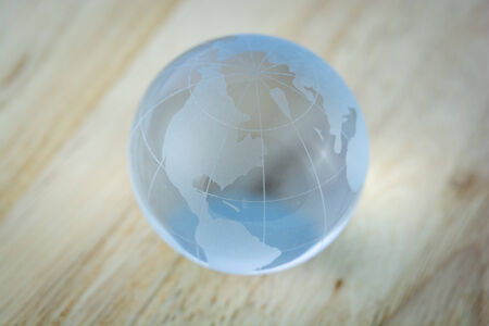 a glass the world on wooden backgroundの写真素材