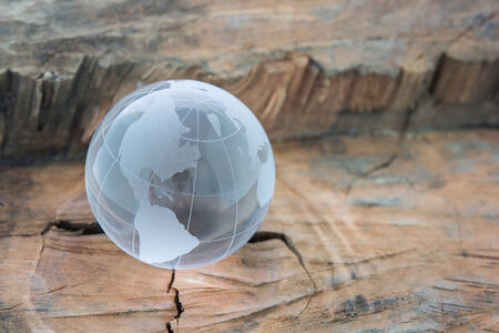 a glass the world on wooden backgroundの写真素材