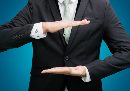 Businessman standing posture show hand isolated on over blue backgroundの写真素材
