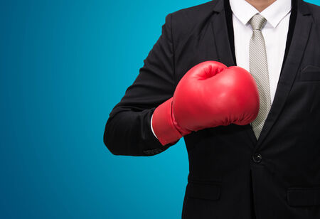 Businessman standing posture in boxing gloves isolated on over blue backgroundの写真素材