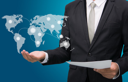 Businessman standing posture hand holding Earth icon isolated on over blue backgroundの写真素材