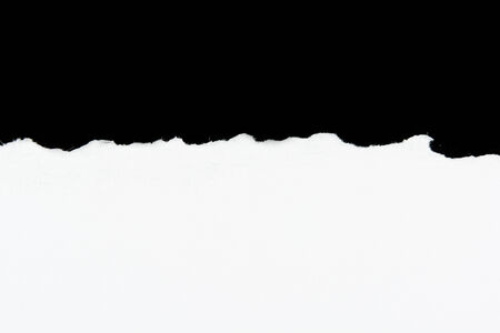 tear white paper pieces of paper on black backgroundの写真素材