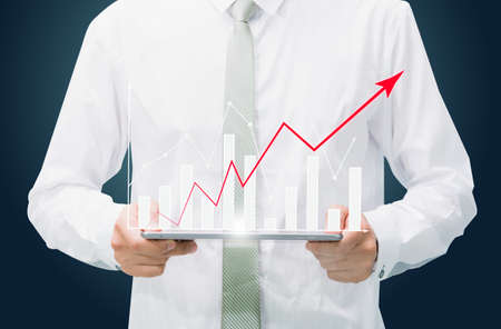 Businessman standing posture hand graph on tablet isolated on dark background