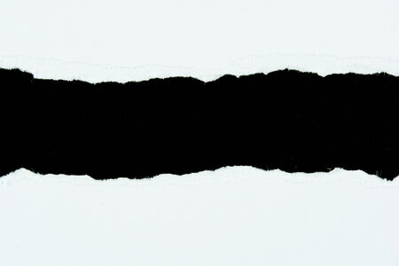 tear white paper pieces of paper on black backgroundの写真素材