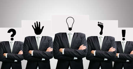 Businessman standing white paper ideas face holding front of head on gray backgroundの写真素材