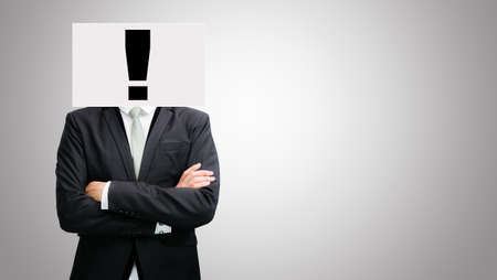 Businessman standing white paper ideas face holding front of head on gray backgroundの写真素材