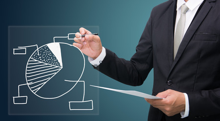 Businessman standing posture hand hold a pen isolated on dark backgroundの写真素材