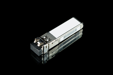 Optical gigabit SFP module for network switch isolated on over black backgroundの写真素材