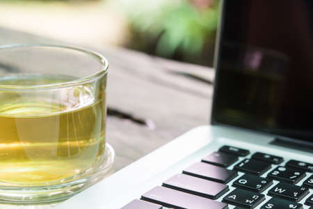White laptop and tea cup business on wood table