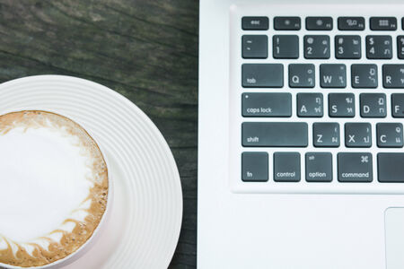 Coffee cup and laptop business on wood tableの写真素材