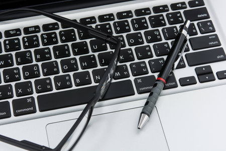 Blank business laptop, mouse, pen and glasses on white table