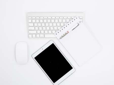 Business desk with a keyboard, mouse and pen on white tableの写真素材