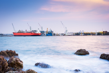 Cargo ship loading in cargo terminal on sunset in Thailand
