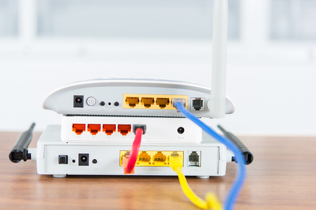 Wireless modem router network hub with cable connect on wooden table in the room