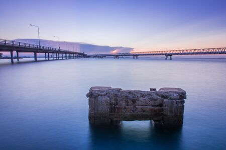 Concrete Bridge over sea water with sunrise at Sriracha Harbour Port of Thailandの写真素材
