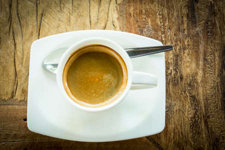 Coffee cup and laptop in coffee shop on wooden tableの写真素材