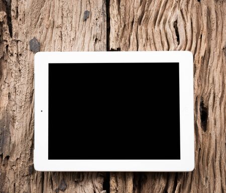 White Tablet pc on old wooden tableの写真素材