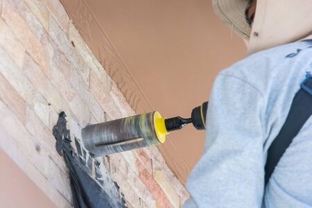 worker with rock drill the wall for air conditionerの写真素材