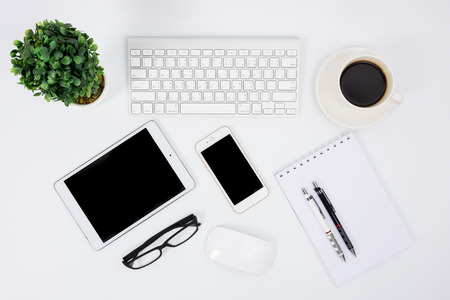 Business desk with a keyboard, mouse and pen on white tableの写真素材