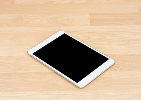 White digital tablet on wooden table backgroundの写真素材