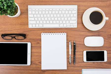 Business desk with a keyboard, mouse and pen on wooden tableの写真素材