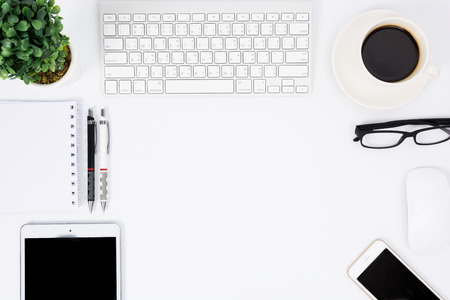 Business desk with a keyboard, mouse and pen on white tableの写真素材
