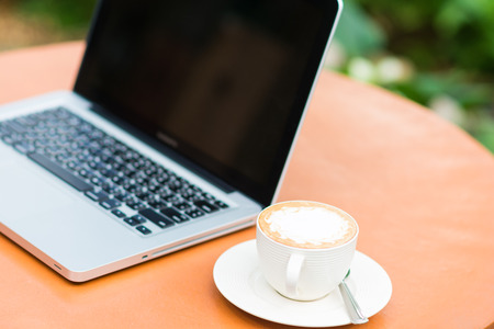 laptop and coffee outdoors in cafeの写真素材