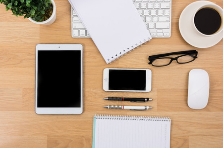Business desk with a keyboard, mouse and pen on wooden tableの写真素材