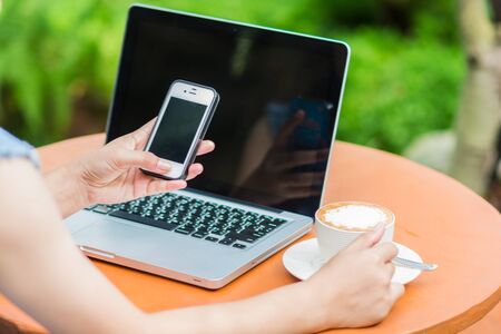Woman hands typing on laptop outdoors in cafeの写真素材