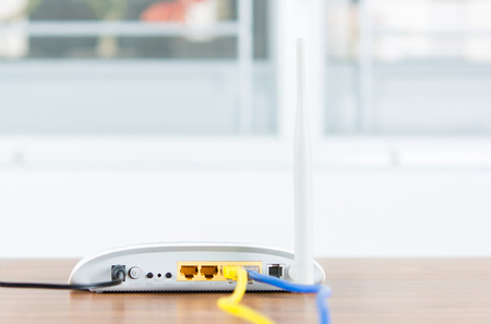 Wireless modem router network hub with cable connect on wooden table in the roomの写真素材