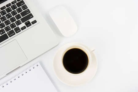 Notebook laptop and coffee cup on white tableの写真素材